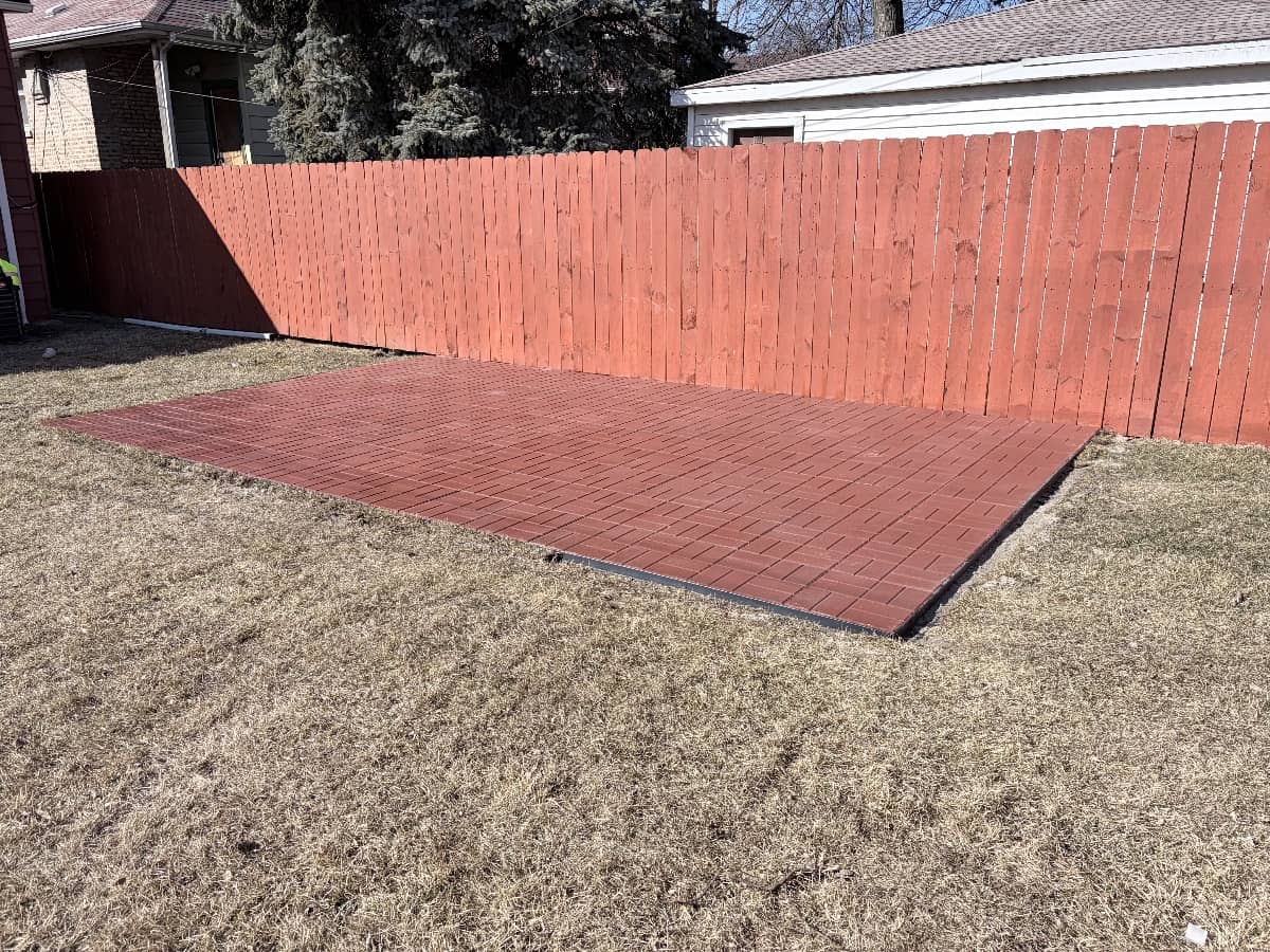 red paver patio with red fence in the backg