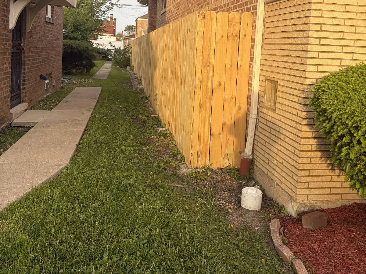 fresh mulch installed alongside wood fence