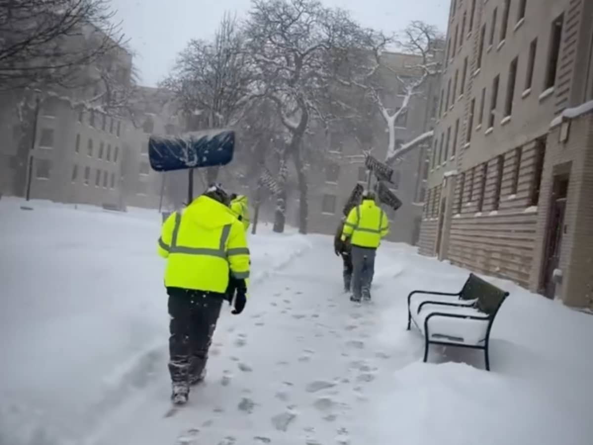 Employees holding their snow shoveling equipment